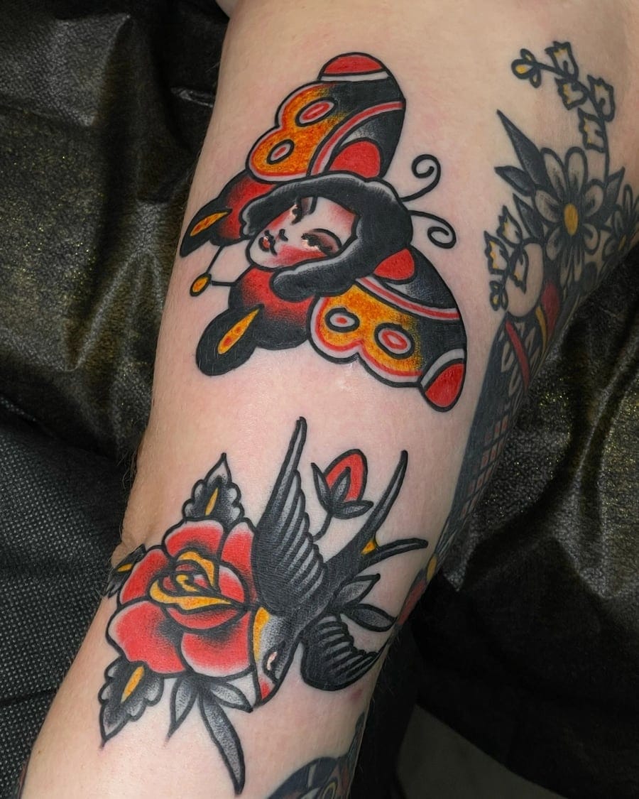 Neo-traditional arm tattoo of a woman framed by a butterfly, above a rose and a swallow