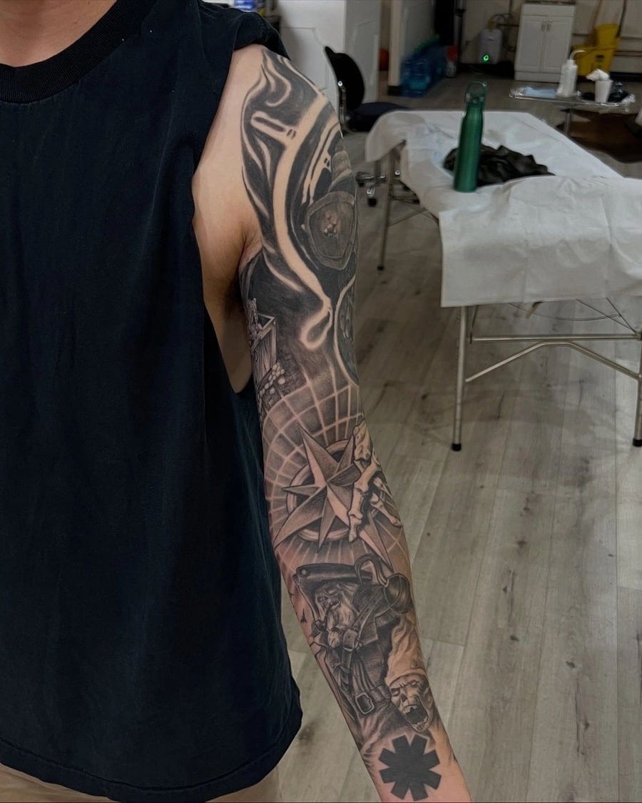 Second angle of a black and grey realism arm sleeve showing skull and shaded detail work