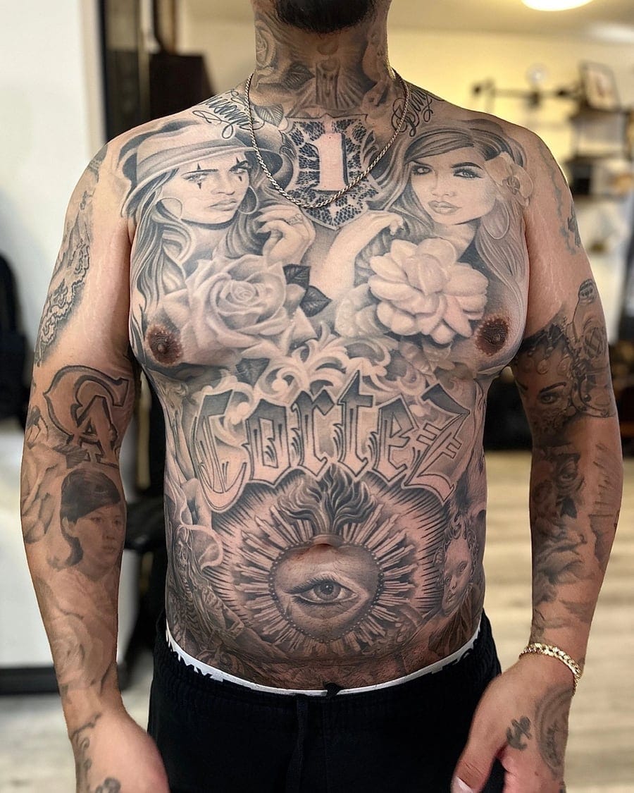 Black and grey full chest and stomach panel with portraits, floral work, lettering and an all-seeing eye