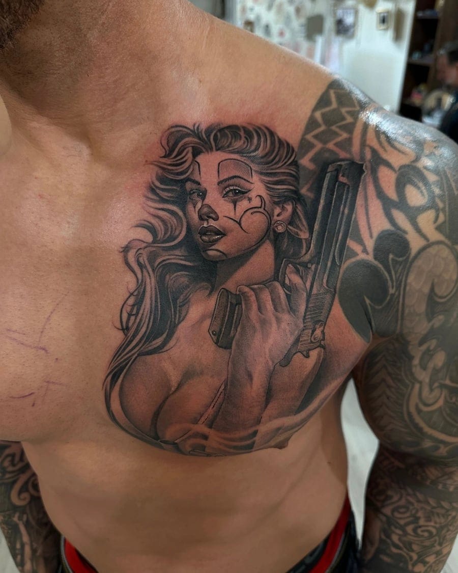 Black and grey chest tattoo of a woman holding a revolver in Chicano tattoo style