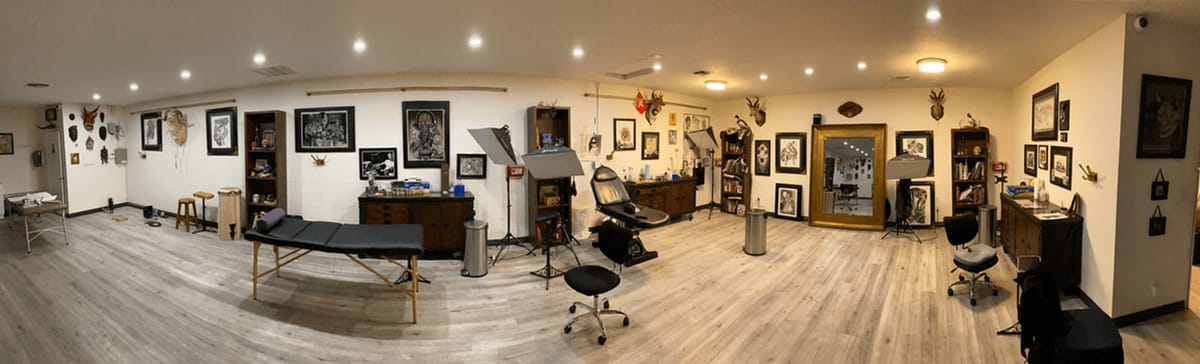 Inside Broken Heart Tattoo in Hillcrest, San Diego, showing the open studio floor with stations, artwork and a mirrored wall